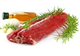 trimmed rack of raw lamb with oregano, garlic, rosemary and vinegar