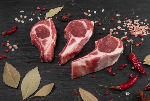 Three raw lamb chops with chillies, salt and bay leaves